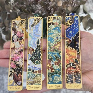 Op de afbeelding: Vier rechthoekige metalen bladwijzers met ingewikkelde uitsparingen en kleurrijke emaille ontwerpen geïnspireerd op Van Gogh schilderijen. Elke bladwijzer heeft een kwastje en de tekst Van Gogh onderaan.