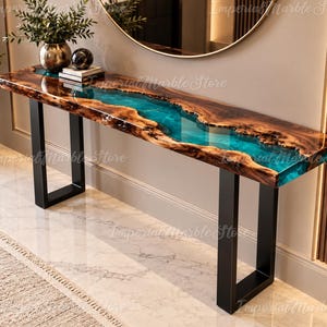 Può includere: Un tavolo console rettangolare caratterizzato da un piano in legno con bordo naturale e un inserto centrale in resina turchese traslucida. Il tavolo è sostenuto da due gambe in metallo nero a forma di U e presenta una finitura lucida.