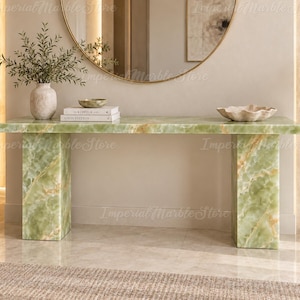 Peut inclure: Une console rectangulaire fabriquée en pierre d'onyx vert clair avec des veines naturelles blanches et dorées. La table présente une surface supérieure plate soutenue par deux pieds épais en forme de dalles rectangulaires, finition polie.