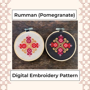 May include: Two embroidery hoops with cross-stitch patterns. One is on white fabric, the other on black. Both feature a symmetrical design in red, pink, and gold. Text reads "Rumman (Pomegranate)" and "Digital Embroidery Pattern."