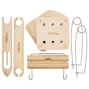 May include: A set of light-colored wooden weaving tools including two shuttles, a stack of square cards with holes labeled A, B, C, and D, a horizontal bar with two hooks, and two large metal safety pins. Each wooden piece is branded with the word Sujur.