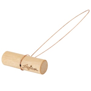 May include: A light-colored wooden cylinder tool featuring a thin, flexible copper-colored wire loop attached to the center. The word Sujur is engraved in a cursive script on the side of the wooden handle, which has a smooth, natural finish.