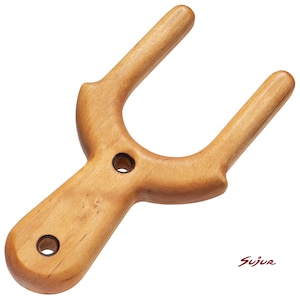 May include: A light brown wooden boot jack with a U-shaped opening for removing footwear. The tool features a smooth, polished finish and two circular holes drilled into the handle section. The word Sujur is printed in red in the bottom corner.