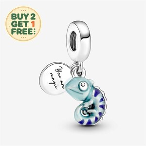 May include: A silver charm featuring a light blue and dark blue striped chameleon pendant and a round silver disc engraved with the text You are magic. The charm includes a polished silver bail for attachment to a bracelet or necklace chain.
