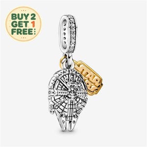 Może przedstawiać: Srebrny charms w kształcie statku kosmicznego Millennium Falcon z misternymi detalami mechanicznymi. Uchwyt jest wysadzany przezroczystymi kamieniami, a obok wisi złoty metalowy element z wytłoczonym napisem STAR WARS.