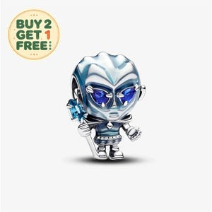 May include: A silver-toned charm bead shaped like a stylized character with a large head, pointed ears, and deep blue heart-shaped eyes. The figure wears a dark blue outfit and holds a staff topped with a light blue crystal-like stone.