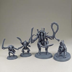 May include: A set of four unpainted grey plastic miniature figures standing on circular bases. The group includes three bipedal creatures with sharp blades and one quadrupedal creature featuring a large cannon-like weapon mounted on its back.
