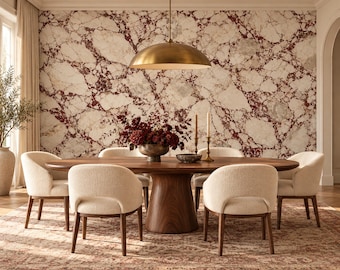 May include: A dining room featuring a large oval wooden table with a pedestal base, surrounded by six cream-colored upholstered chairs. A brass dome pendant light hangs above, and a wall with white and dark red marble pattern serves as a backdrop.