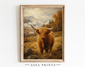 May include: A framed wall art print featuring a long-haired Highland cow standing in a grassy field with mountains and autumn trees in the background. The text ASSA PRINTS is printed in black at the bottom center of the frame.
