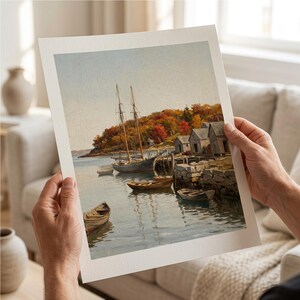 May include: A rectangular art print featuring a landscape painting of a harbor with a two-masted sailboat, several small wooden rowboats, and stone buildings on the shore. The scene includes autumn-colored trees in shades of orange and red.