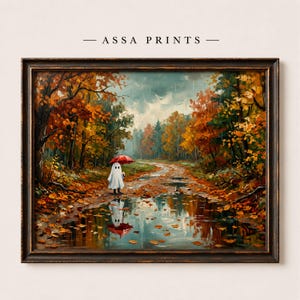 May include: A framed wall art print titled ASSA PRINTS featuring an oil painting of a white ghost holding a red umbrella on a muddy path through an autumn forest with orange and yellow trees, rain, and a reflection in a puddle on the ground.