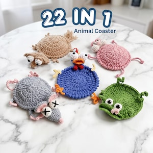 May include: Five crocheted animal coasters with the text 22 IN 1 Animal Coaster. The set includes a tan turtle, a pink pig, a blue chicken, a gray mouse with X-shaped eyes, and a green frog, all featuring round bodies and small limbs.