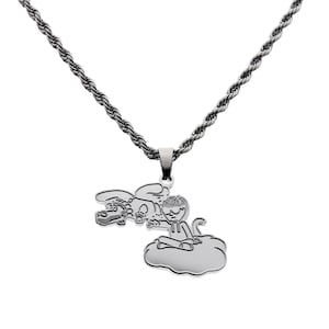 May include: A silver-toned metal necklace featuring a rope chain and a pendant depicting a cartoon-style character with spiky hair sitting on a cloud, reaching toward a dragon-like creature flying horizontally above the cloud in a line-art style.