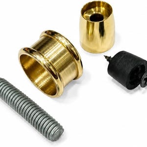 May include: A set of hardware components including a cylindrical brass sleeve with a flanged rim, a smaller tapered brass cap, a black rubber stopper with a central screw, and a long, threaded silver-colored metal bolt for assembly.