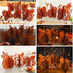 Op de afbeelding: Een collectie oranje, lasergesneden houten pompoendecoraties met ingewikkelde filigraanpatronen, stelen en bladeren. Deze driedimensionale, vrijstaande ornamenten zijn ontworpen met in elkaar grijpende panelen voor een gelaagde structuur.