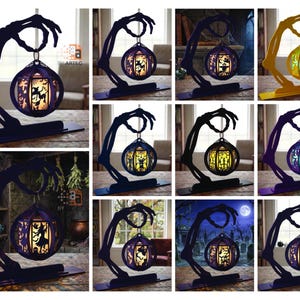 Puede incluir: Una colección de lámparas de mesa decorativas con una base de mano esquelética que sostiene una linterna esférica. Las linternas presentan intrincadas siluetas recortadas de brujas, murciélagos y calabazas, iluminadas desde el interior.