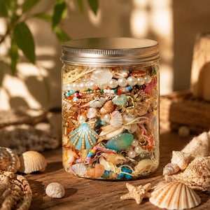 May include: A clear glass jar with a silver metal lid filled with a collection of assorted jewelry, including white pearls, gold-toned chains, colorful beads, and various small seashell charms in shades of blue, tan, and iridescent white.