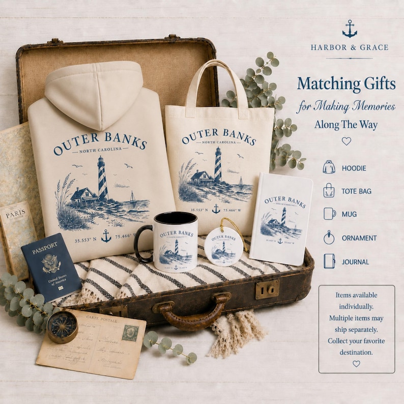 Pu&ograve; includere: Una felpa con cappuccio color crema, una borsa di tela, una tazza in ceramica, un ornamento rotondo e un diario, tutti decorati con un faro blu e la scritta Outer Banks. Questi articoli sono disposti all'interno di una valigia vintage.