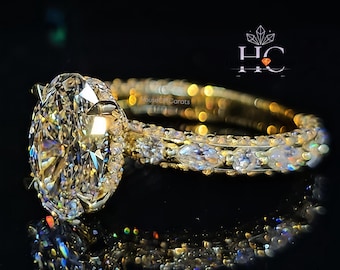 Anel de noivado em ouro amarelo 14K com moissanita oval de 3 quilates com diamantes em corte "crushed-Ice", aliança cravejada com diamantes redondos em formato de marquise e pavé, e halo oculto.