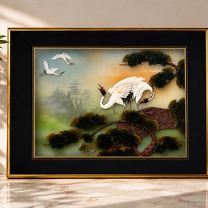 May include: A framed wall art piece featuring a three-dimensional scene of white cranes with red crests perched on dark green pine branches, with two cranes in flight against a soft, hazy background of distant mountains and a golden sky.