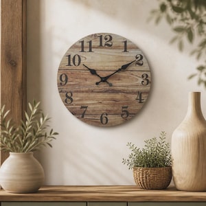 May include: A round wall clock with a light brown wood grain finish and dark brown numerals from one to twelve. The clock features two black metal hands positioned at the centre, displaying a time of approximately ten minutes past ten.