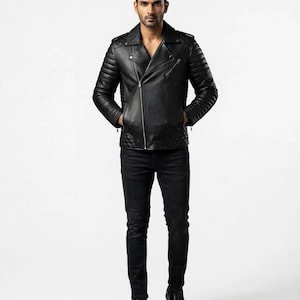 May include: A black leather motorcycle jacket featuring an asymmetrical silver zipper, quilted shoulder and side panels, notched lapels, and zippered pockets, paired with slim-fit black denim jeans and black leather boots.