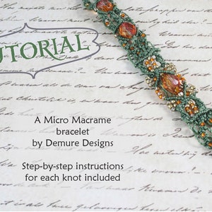 Puede incluir: Un brazalete de macramé verde y marrón con cuentas. El brazalete está sobre un trozo de papel con texto escrito a mano que dice "Tutorial", "Un brazalete de macramé micro de Demure Designs", y "Instrucciones paso a paso para cada nudo incluido".