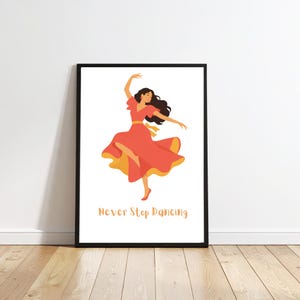 May include: A framed wall art print featuring a stylised illustration of a person with long dark hair dancing in a flowing coral-coloured dress with a yellow lining. The text "Never Stop Dancing" is printed in a light orange script below the figure.