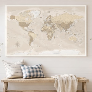 Peut inclure: Une grande carte murale rectangulaire du monde présentant une palette de couleurs neutres dans les tons beige, crème et brun clair. La carte affiche les continents, les pays et les océans avec des étiquettes claires et une rose des vents.