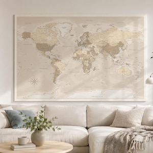 Op de afbeelding: Een grote rechthoekige wereldkaart voor aan de muur met een neutraal beige en crème kleurenpalet. De kaart toont continenten, landen en oceanen met duidelijke tekstlabels, inclusief een windroos in de linkerbenedenhoek.