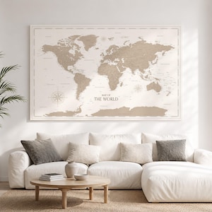 Peut inclure: Une grande carte murale rectangulaire intitulée MAP OF THE WORLD avec un schéma de couleurs beige et blanc. La carte affiche les continents dans un ton brun clair sur un fond crème, incluant des roses des vents et des régions géographiques.