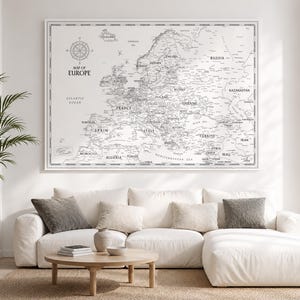 Può includere: Una grande stampa artistica da parete rettangolare che presenta una dettagliata mappa dell'Europa in bianco e nero. La mappa include una rosa dei venti nell'angolo in alto a sinistra e il testo Map of Europe. Il design mostra confini nazionali.
