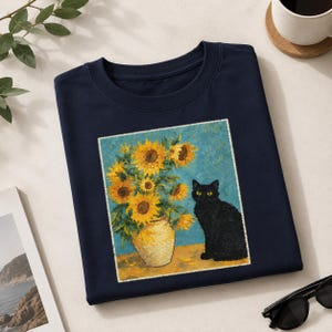 Può includere: Una t-shirt blu navy a girocollo con una stampa grafica rettangolare raffigurante un gatto nero seduto accanto a un vaso giallo pieno di girasoli giallo brillante su uno sfondo blu testurizzato, in uno stile artistico impressionista.