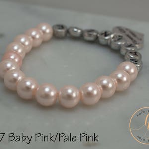 May include: A pale pink pearl bracelet with a silver charm that says "Mommy's Little Girl".