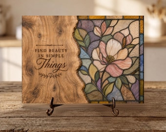 Puede incluir: Una placa decorativa rectangular con un lado izquierdo de veta de madera con el texto "FIND BEAUTY IN SIMPLE THINGS" y un lado derecho que muestra un patrón floral de vidrieras en tonos rosa, morado, verde y amarillo sobre un soporte.