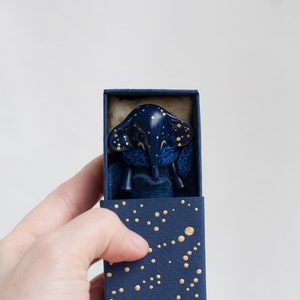 Miniature starry blue elephant toy in a matchbox bed