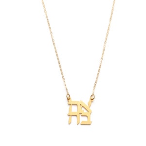 May include: A gold chain necklace with a pendant featuring the Hebrew letters 'Chai' in a stylised font.