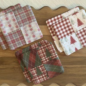 Puede incluir: Tres juegos de posavasos cuadrados de tela con diseños de patchwork. Un juego muestra patrones de copos de nieve y cuadros rojos y blancos. Otro juego presenta estampados de cuadros vichy y árboles de Navidad. El tercer juego tiene motivos de rombos y árboles verdes y rojos.