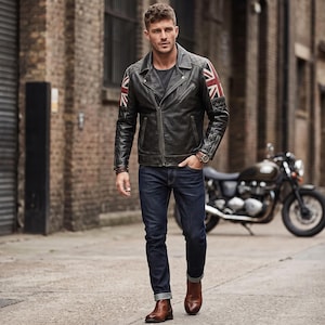 May include: A black leather motorcycle jacket featuring quilted shoulder panels and Union Jack flag patches on the sleeves, worn with a dark gray t-shirt, dark blue denim jeans, and brown leather boots, standing in an urban alleyway.