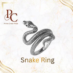 May include: A silver-toned metal ring shaped like a coiled snake with detailed scale textures. The text Prime Crest Finds and PC are visible in the upper left corner, and the text Snake Ring is centered at the bottom of the image.