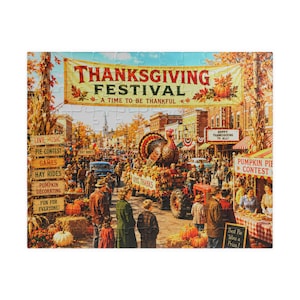May include: A jigsaw puzzle depicting a Thanksgiving Festival scene with a large banner reading THANKSGIVING FESTIVAL A TIME TO BE THANKFUL. The image shows a town street with a turkey float, people, pumpkins, and signs for pie and pumpkin contests.