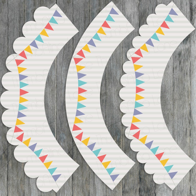May include: Three printable cupcake wrappers with a scalloped edge and a design of colorful triangle flags. The wrappers are white with gray stripes and the flags are red, yellow, blue, and purple.