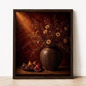 Könnte beinhalten: Ein gerahmter Kunstdruck mit einer dunkelbraunen, texturierten Keramikvase mit Wellenmuster, gefüllt mit einem Strauß kleiner gelber und orangefarbener Blumen. Eine flache Schale mit Feigen und einem halbierten Granatapfel steht neben der Vase.