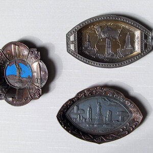 Puede incluir: Tres bandejas de metal vintage con dise&ntilde;os en relieve. Una es una bandeja redonda con forma de flor con un centro azul que representa la Estatua de la Libertad. Otra es una bandeja ovalada con monumentos de la ciudad. La tercera es una bandeja en forma de hoja con el horizonte de Nueva York.