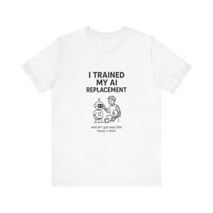 Peut inclure: Un t-shirt blanc à manches courtes avec un motif noir représentant une personne interagissant avec un robot. Le texte indique : I TRAINED MY AI REPLACEMENT and all I got was this lousy t-shirt. Le motif est centré sur la poitrine du vêtement.