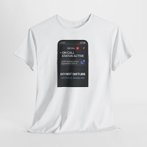 May include: A white short-sleeved t-shirt featuring a graphic of a smartphone screen displaying the text ON CALL STATUS ACTIVE, ALERT: Multiple Service Degradations (SEV-1), DO NOT DISTURB, and the parenthetical text (my anxiety already did).