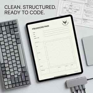 May include: A digital tablet displaying a pseudocode page template with a grid, alongside a grey mechanical keyboard and a USB-C hub. The screen features the text "CLEAN. STRUCTURED. READY TO CODE." and "PSEUDOCODE PAGE" with a logo for Falcon Digital Studio.