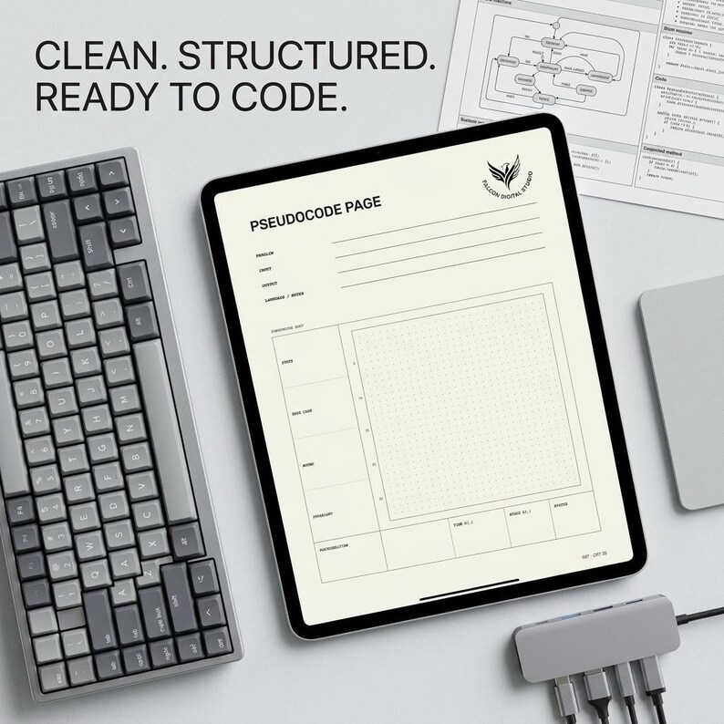 May include: A digital tablet displaying a pseudocode page template with a grid, alongside a grey mechanical keyboard and a USB-C hub. The screen features the text "CLEAN. STRUCTURED. READY TO CODE." and "PSEUDOCODE PAGE" with a logo for Falcon Digital Studio.