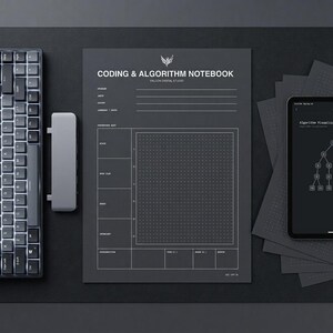 May include: A dark gray coding and algorithm notebook with white grid lines, headers, and text including "CODING & ALGORITHM NOTEBOOK" and "FALCON DIGITAL STUDIO" positioned next to a computer keyboard, a gray rectangular hub, and a smartphone.