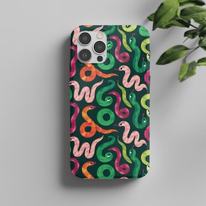 Puede incluir: Una funda para smartphone con fondo verde oscuro y un patrón repetitivo de serpientes estilizadas en tonos rosa, naranja y verde claro. Las serpientes aparecen en varias posiciones enroscadas y sinuosas con ojos y lenguas visibles.